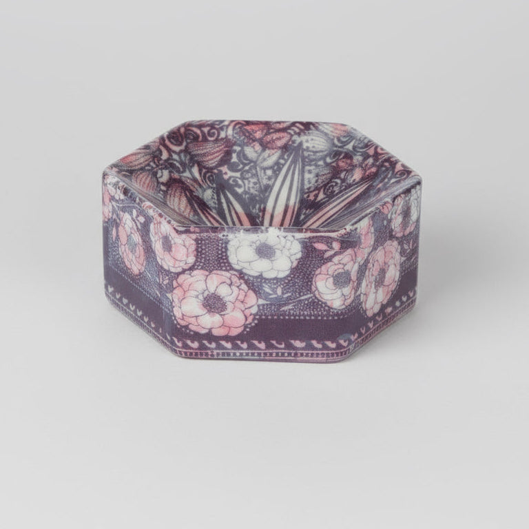 Hexagonal decorative dish with floral pattern on a light gray background