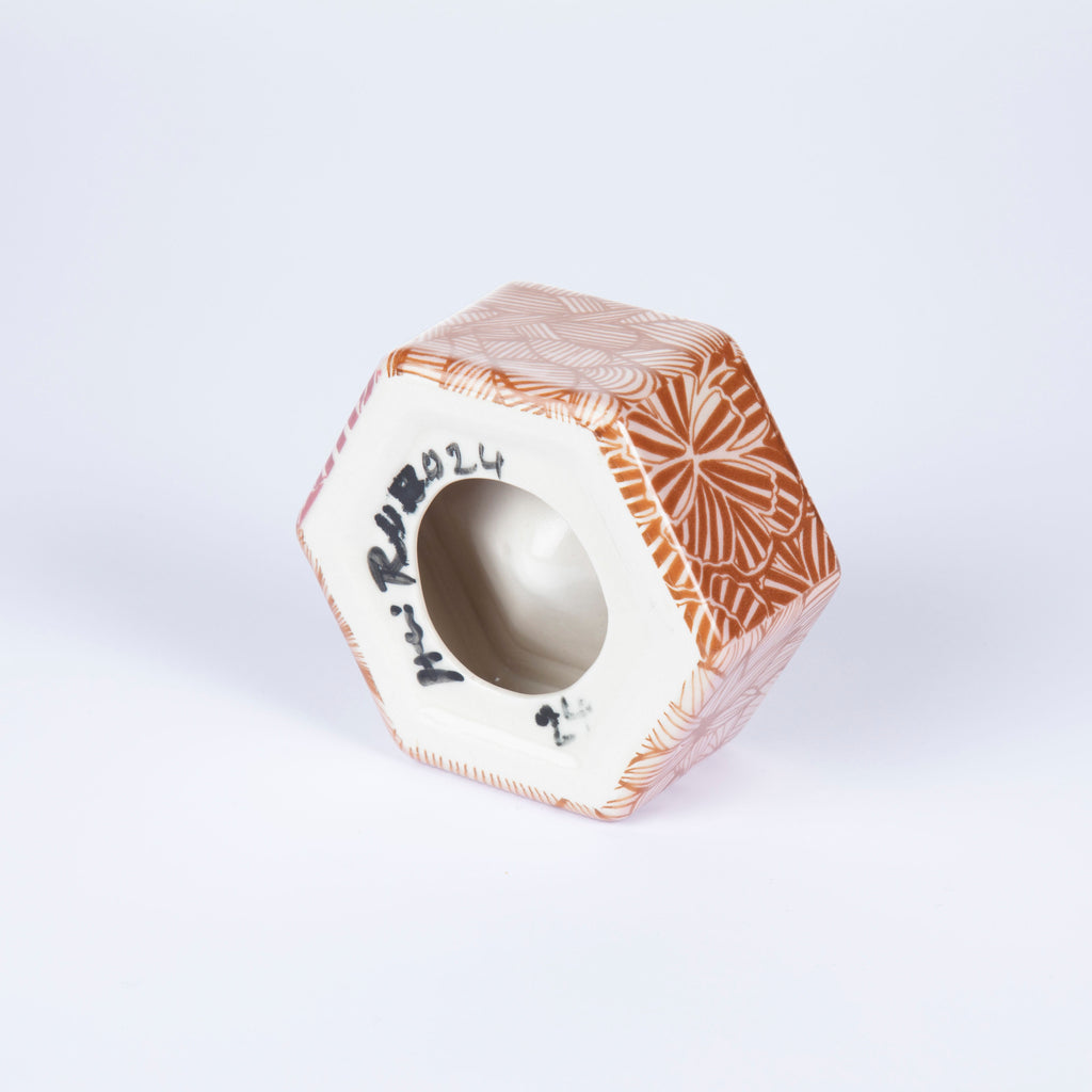 Hexagonal ceramic product with decorative patterns on a light gray background